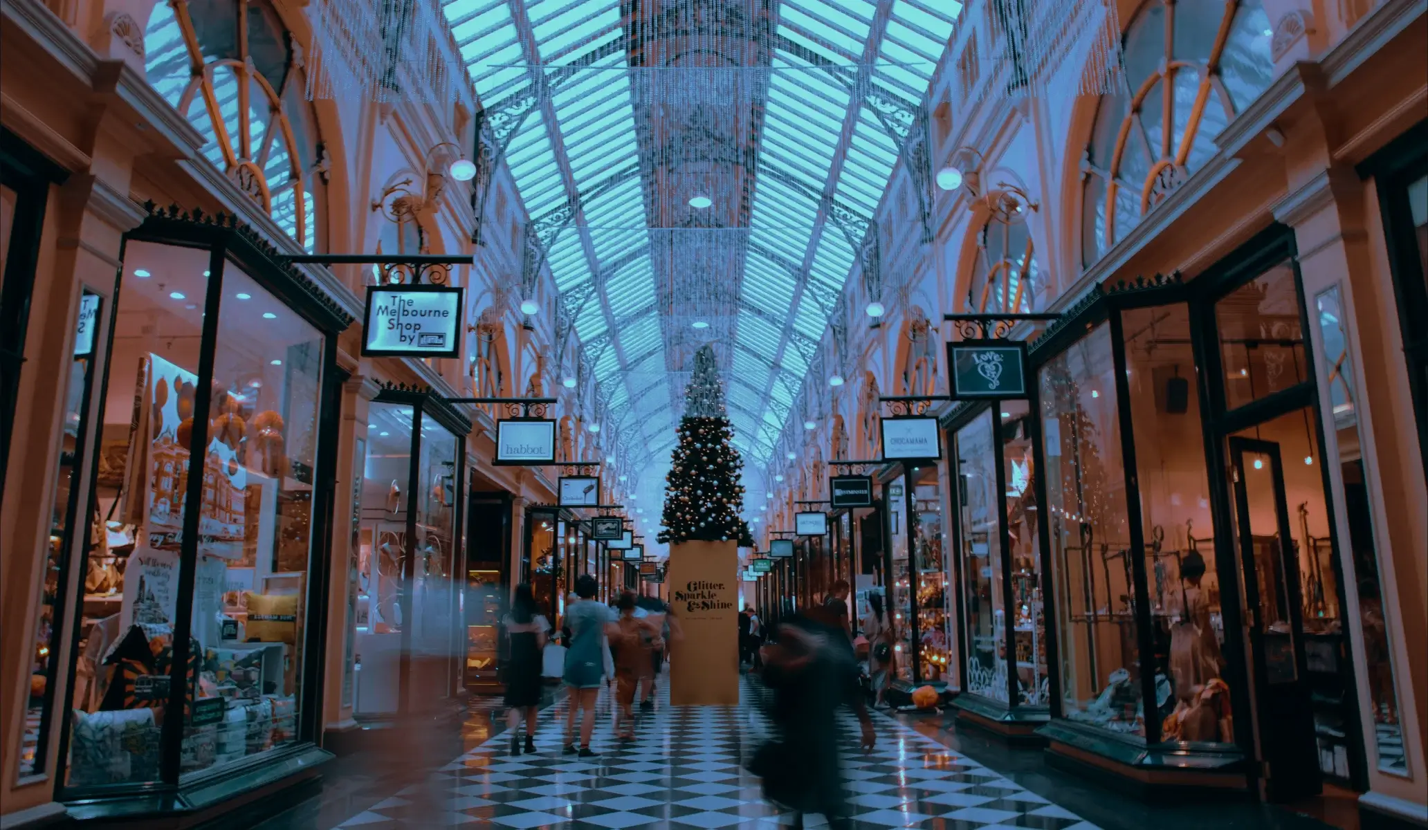 The interior of an elegant Victorian shopping arcade with a Christmas tree and glass ceiling